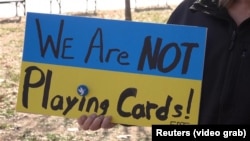 Протестувальники біля Білого дому у Вашингтоні 1 березня тримали плакати із написом «Ми не граємо у карти», апелюючи до заяви Трампа про те, що в Зеленського «не залишилося карт»