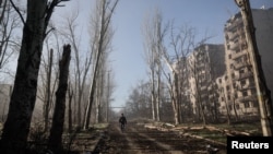 Чоловік проходить повз житлові будинки, пошкоджені внаслідок російського військового удару у прифронтовому місті Костянтинівка, листопад 2025 року 