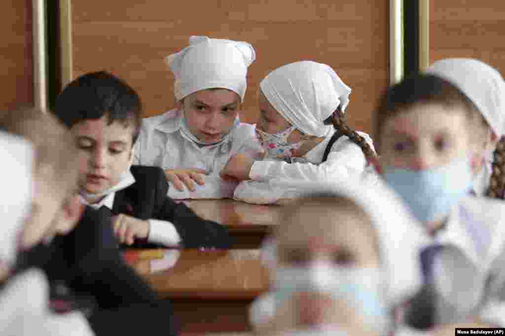 Pupils wearing face masks sit in a classroom during the Day of Knowledge ceremony marking the start of classes in the Chechen capital, Grozny, on September 1.