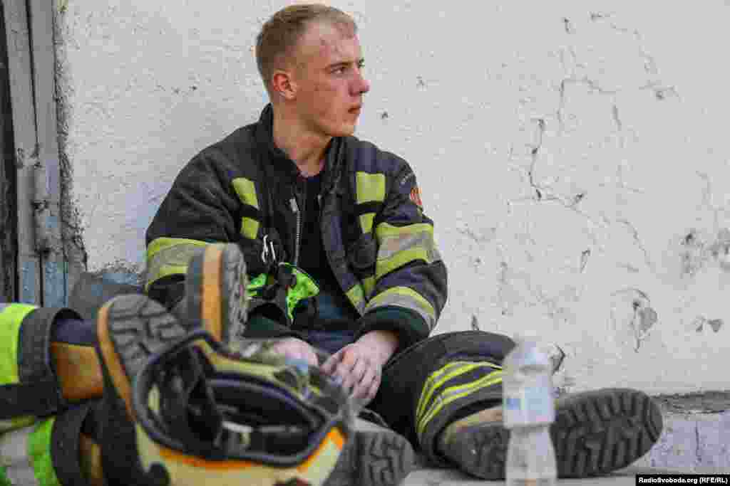 Рятувальник відпочиває після роботи на місці ракетного удару 