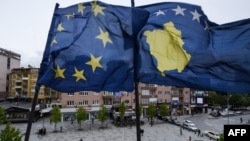 Kosovar Albanians walk under the EU and Kosovo flags in the main square of Pristina on May 4.