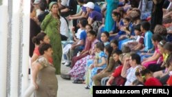 Çagalar ulularyň gözegçiliginde sport ýaryşyna tomaşa edýärler.