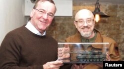 German Defense Minister Boris Pistorius presents a miniature copy of a Leopard tank to his Ukrainian counterpart, Oleksiy Reznikov, in Kyiv on February 7. 