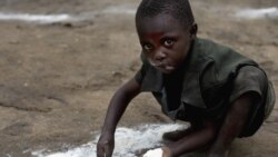 Ребенок в Конго собирает муку с земли. Архивное фото.