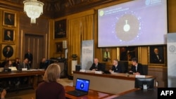 Зліва направо члени Нобелівського комітету з фізики: голова Матс Ларссон, генеральний секретар Ґоран Ганссон та професор Ульф Даніельсон під час оголошення імен лауреатів Нобелівської премії 2019 року