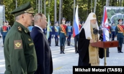 Зліва направо: міністр оборони Росії Сергій Шойгу, російський президент Володимир Путін і патріарх РПЦ Кирило під час закладення каменя в фундамент головного храму Збройних сил Росії на території військово-патріотичного парку «Патріот». Московська область, 19 вересня 2018 року