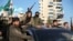 Anti-government fighters brandish their guns as they ride a vehicle in Syria's northern city of Aleppo on November 30, 2024.
