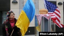 Ілюстративне фото. Жінка з прапором України біля посольства США у Києві. За окремими повідомленнями, Вашингтон може запровадити санкції проти окремих українських чиновників.