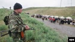 Кыргыз чек арачысы Анжияндан оогон өзбек качкындарын күзөтүп турат. Оштун Бараш айылы, 19-май, 2005-жыл.