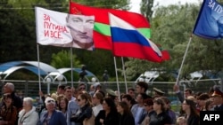 Днестр боюндагылар Орусия желегин жана В.Путиндин сүрөтүн Тирасполдогу жыйында көтөрүп турушат. Молдова. 09.9.2014. AFP.