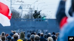 Супрацоўнікі беларускага АМАПу — на барыкадзе, якая блякуе вуліцу падчас мітынгу ў знак пратэсту супраць афіцыйных вынікаў прэзыдэнцкіх выбараў у Менску, Беларусь, 25 кастрычніка 2020 году