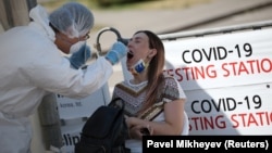 Алматыдағы арнайы орталыққа келген адамнан тест алып жатқан дәрігер. 17 маусым 2020 жыл.
