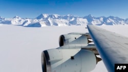 A NASA photo shows the wing of a DC-8 as it flies past Antarctica's tallest peak, Mount Vinson, during research on polar warming in 2012.