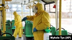 Санитардык кызматкерлер Киевдеги автобусту дезинфекциялап жатышат, 3-март 2020-жыл. 
