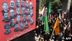 Люди проходять повз плакат із портретами вчених і військових командирів, загиблих під час 12-денної війни між Іраном й Ізраїлем, Тегеран, 5 липня 2025 року