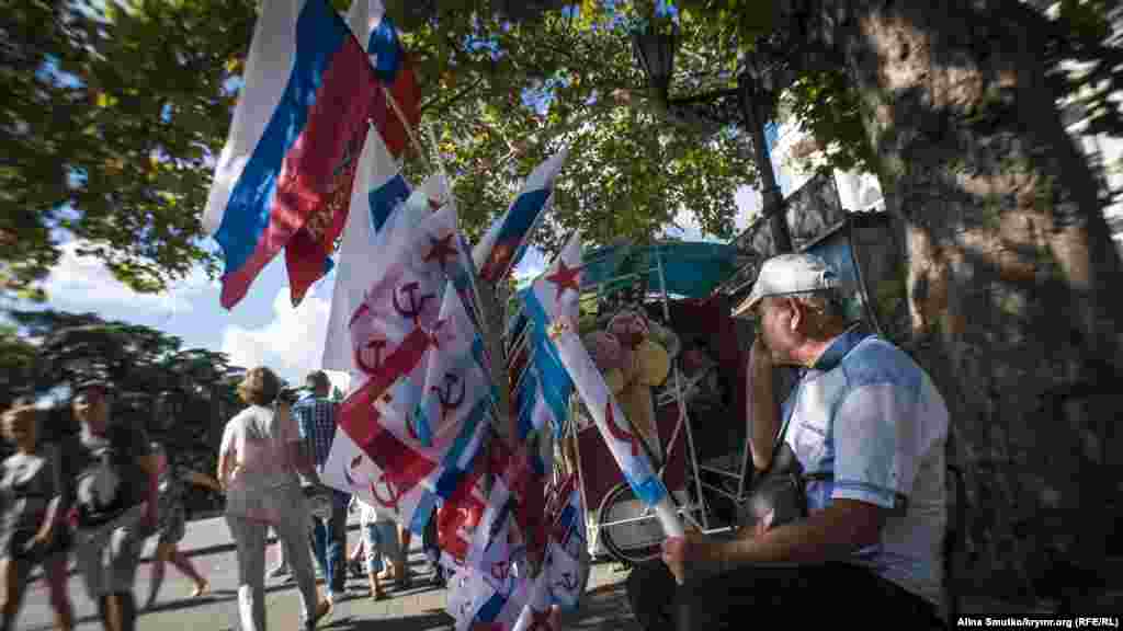 Продавець радянських та російських прапорів під час&nbsp;відзначення Дня військово-морського флоту Росії в окупованому Севастополі, 30 липня 2017 року ПЕРЕГЛЯНЬТЕ ФОТОГАЛЕРЕЮ