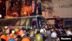 Автобус с солдатами внутренних войск покидает место демонстрации протеста. Киев, 21 февраля 2014 года.