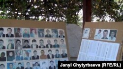 Дайынсыз жоголгондордун сүрөттөрү чапталган такта.