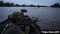 Українські військові пливуть на човнах по Дніпру на передовій поблизу Херсону, 11 червня 2023 року