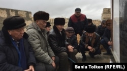 Жаңаөзен оқиғасы құрбандарының зираты басында құран оқып отырған адамдар. Теңге ауылы, Маңғыстау облысы. 10 желтоқсан 2016 жыл.