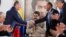 The head of the Russian state oil firm Rosneft, Igor Sechin, (left) shakes hands with the Venezuelan oil minister and the president of the South American country's state oil company PDVSA, Manuel Quevedo, in front of Venezuelan President Nicolas Maduro in Maiquetia in December 2017. 