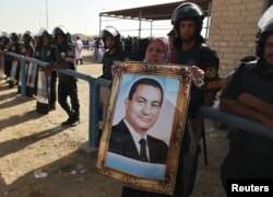 Женщина держит в руках портрет Хосни Мубарака. Каир, 2 июня 2012 года.