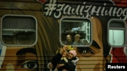 People take selfies in front of the first train to travel to liberated Kherson in Kyiv on November 18.