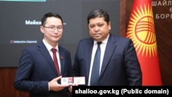 Жаңы мандат алган Табылды Муратбеков жана БШКнын төрагасы Тынчтык Шайназаров. 