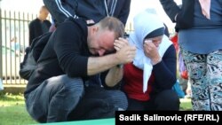 Скорбящие на памятных мероприятиях в честь 24-й годовщины резни в Сребренице. 