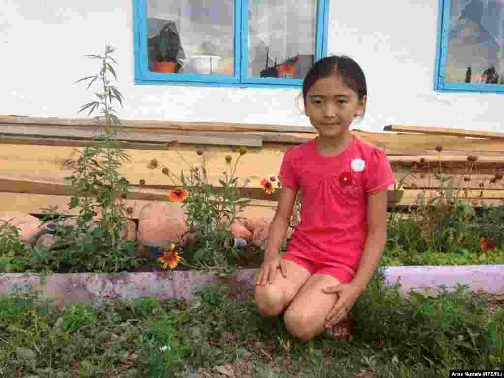 Это девятилетняя младшая дочь Алмагуль &ndash; Зере. Мама с четырёхмесячного возраста укладывала ее в манеж, накрытый тюлью от комаров, а сама работала. Зере очень трудолюбивая, послушная девочка; маму понимает с первого взгляда и быстро делает все что нужно. Говорит, что здесь ей очень нравится, очень любит купаться. Быстро знакомится и находит общий язык с приехавшими на три-четыре дня отдыхать детьми. Любит петь, понравившиеся песни ищет в Интернете и записывает на мобильный телефон.&nbsp;