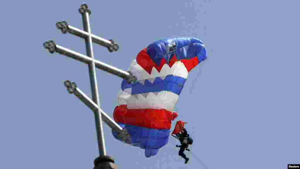 Парашютист с баннером &quot;Христос, воскресе!&quot; над православным храмом в Бишкеке во время пасхальной службы. 