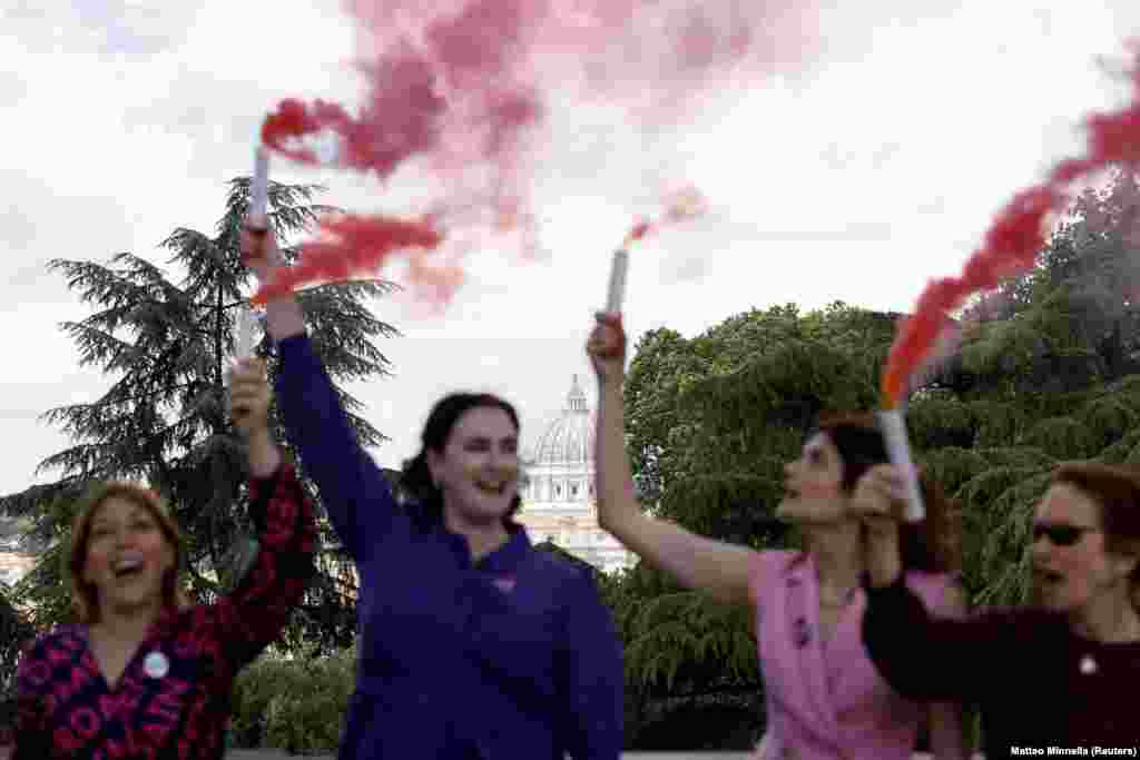 Членкині католицької жіночої групи Women's Ordination Conference тримають фаєри з рожевим димом, закликаючи до рівності жінок у Католицькій церкві та на знак протесту проти конклаву, в якому беруть участь лише чоловіки, Рим, Італія, 7 травня 2025 року