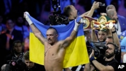 Олександр Усик святкує перемогу над британцем Ентоні Джошуа, захистивши титул чемпіона світу у надважкій вазі на арені King Abdullah Sports City у Джидді (Саудівська Аравія), 21 серпня 2022 року