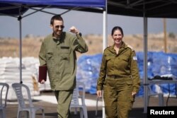 Адзін з вызваленых ізраільскіх закладнікаў, Авінатан Ор (зьлева), ідзе побач з прадстаўніцай ізраільскага войска, 13 кастрычніка 2025