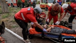 Медики надають допомогу постраждалому на місці удару РФ у Харкові, 18 серпня 2025 року