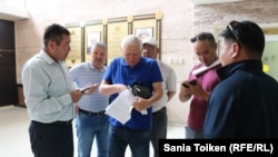 Юрист профсоюза нефтяников OCC Тахир Ерданов (в центре) и активист этого профсоюза Куспан Косшигулов. Актау, 30 мая 2018 года.