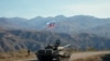 A service member of the Russian peacekeeping troops walks near a tank near the border with Armenia, following the signing of a deal to end the military conflict between Azerbaijan and ethnic Armenian forces