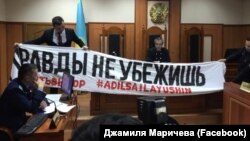 Надпись: «От правды не убежишь» – демонстрируют в зале суда, где рассматривают дело в отношении развернувших баннер активистов. Алматы, 21 апреля 2019 года.
