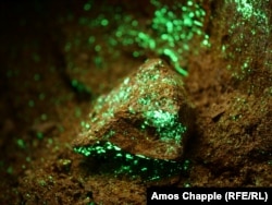 Камни с радиоактивным отенитом в заброшенной урановой шахте советской поры. Минерал светится в ультрафиолетовом свете, который используют для обнаружения радиоактивных отложений