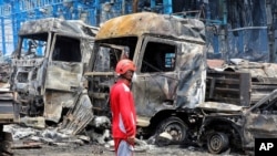 Ирандын түштүгүндөгү Бандар-Аббас порт шаарына жакын жайгашкан Шахид-Ражаи портунда жарылуудан улам күйүп кеткен автоунаалардын жанында турган куткаруучу. 26-апрель, 2025-жыл. 