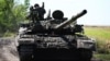 Ukrainian soldiers drive a T-72 tank on the front line in eastern Ukraine in July.