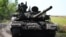 Ukrainian soldiers drive a T-72 tank on the front line in eastern Ukraine in July.