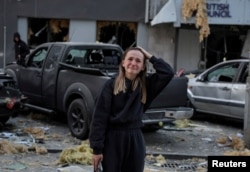 Фото REUTERS. Дівчина плаче біля зруйнованого російським ударом будинку у Києві. 28 серпня 2025 року