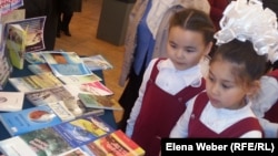 Девочки рассматривают книги на экомарафоне "Знатоки природы".  Караганда, 22 мая 2014 года.