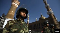 Шыңжаң Ұйғыр автономиялық аймағының Үрімжі қаласында мешіттің алдында күзетте тұрған Қытай қауіпсіздік қызметкері (Көрнекі сурет).