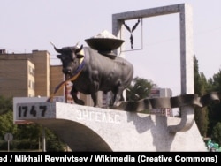 Жовтий Клин. Пам'ятник гербу Енгельського муніципального району. Місто Енгельс Саратовської області, колишня назва – Покровськ, до того це була Покровська слобода, яку заснували українські чумаки у 1747 році. Поволзькі німці називали місто Kosakenstadt