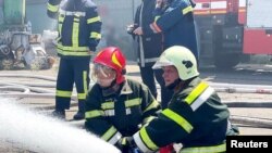 Ýangyn söndürijiler 23-nji iýulda Odesa portunda Russiýanyň raketa zarbasynyň bolan ýerinde işleýärler.