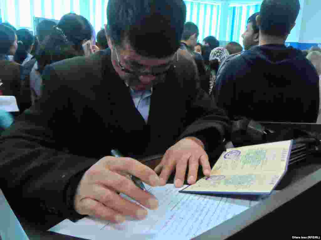 Мужчина заполняет бланк на ярмарке вакансий в Шымкенте.