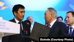 Дуйшонкул Шаматов, потомок Кузебая Куранова, вручает рукопись президенту РК Нурсултану Назарбаеву.