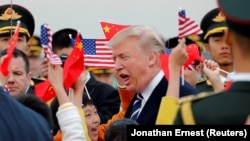 АКШ президентин Американын жана Кытайдын желектерин көтөргөн окуучулар тосуп алышты.